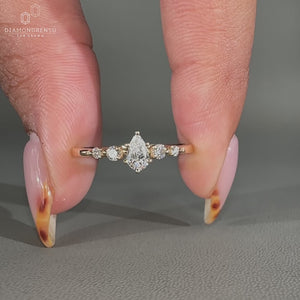 Pear cut engagement ring with 5 stone diamond setting and shared prong design.
