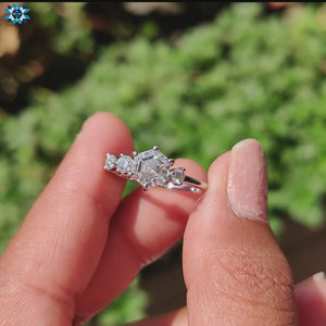 Round cut side stone engagement ring in white gold with moissanite center