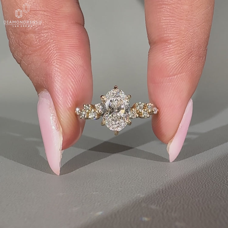 Six claw prong oval ring with sparkling round accents.