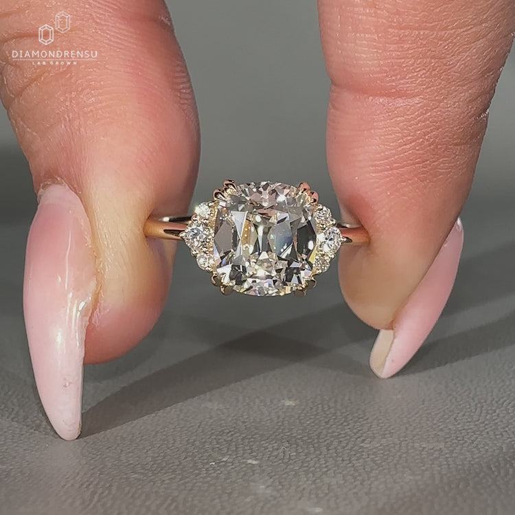 Lab grown old Mine cut diamond ring with round side stones.
