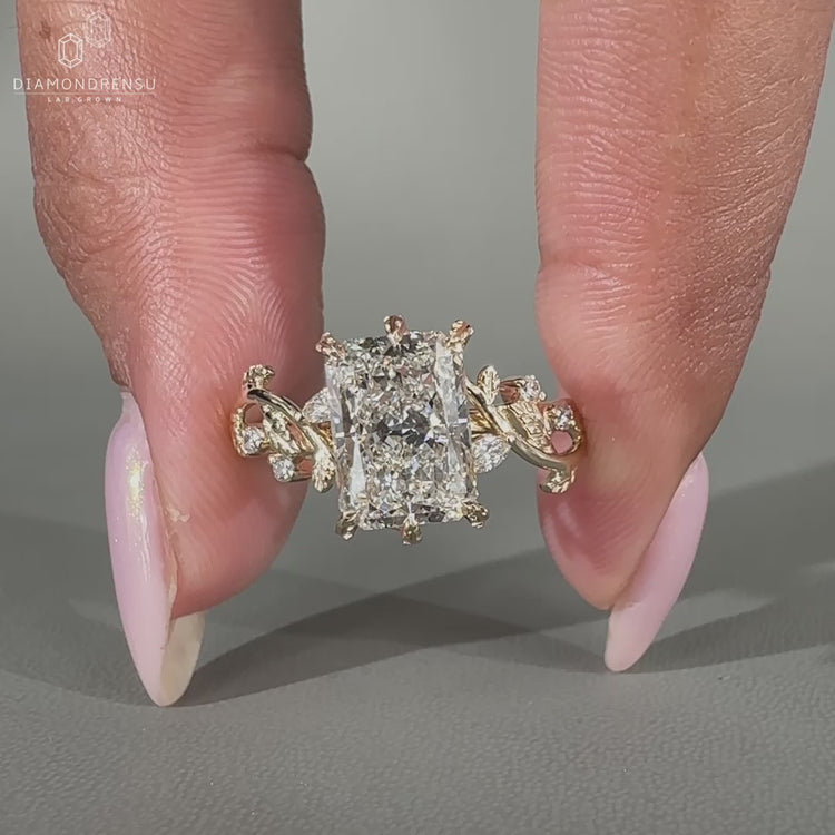 Nature inspired radiant diamond engagement ring with marquise and round side stones
