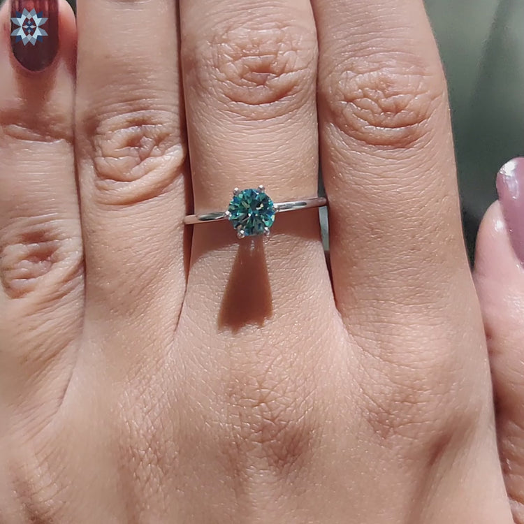 An elegant round engagement ring set against a soft velvet background.
