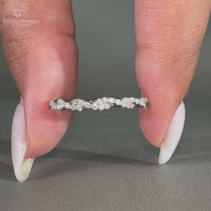 Round diamond wedding band with a twisted design and full eternity setting in white gold.

