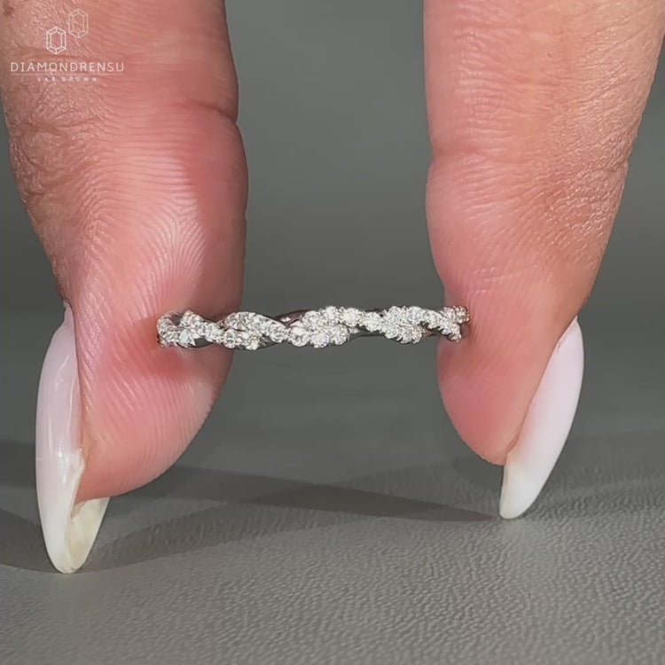 Round diamond wedding band with a twisted design and full eternity setting in white gold.
