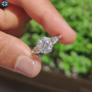 Side stones ring featuring baguette diamonds and moissanite center.
