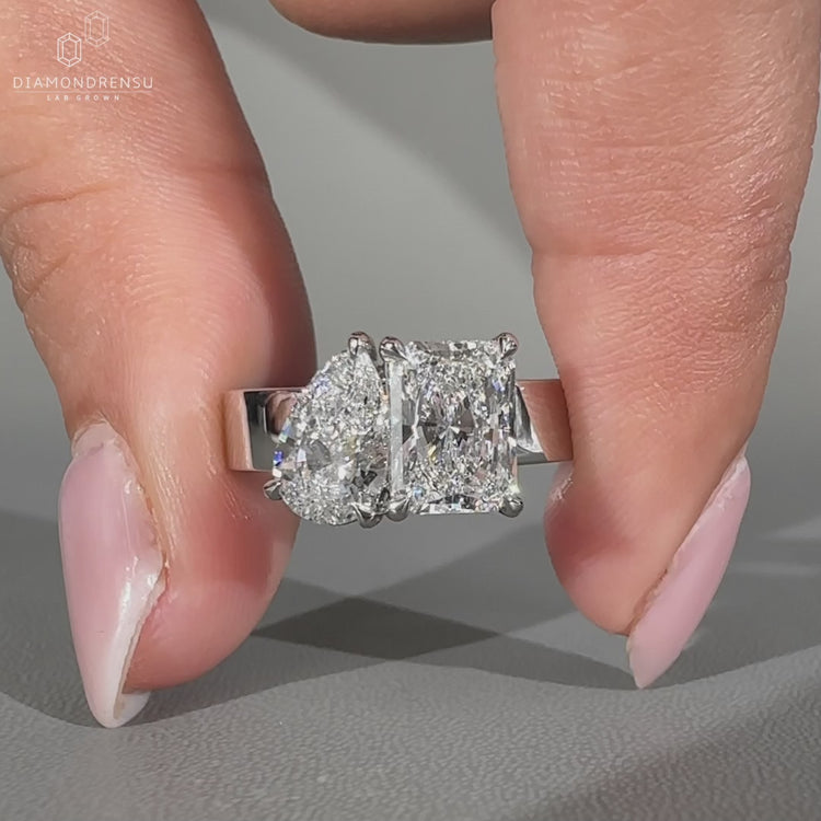 Pear and radiant diamond ring with two stone engagement design.
