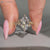 Round side stones frame the marquise center stone.