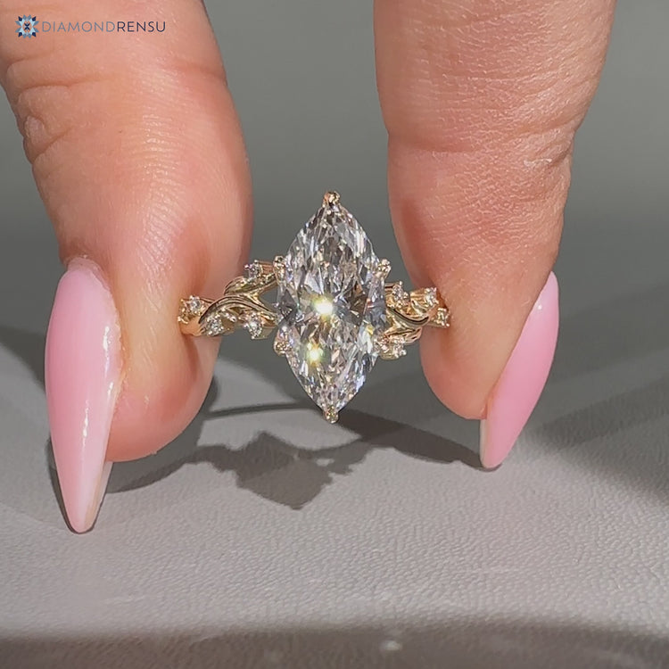 Round side stones frame the marquise center stone.