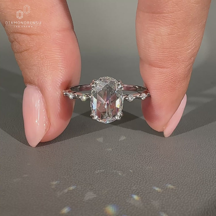 White gold handmade ring with oval rose cut diamond and distance pave.
