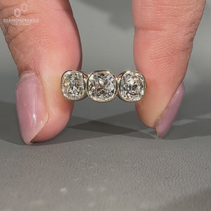 Cushion old european cut diamond with bezel setting and side stones.
