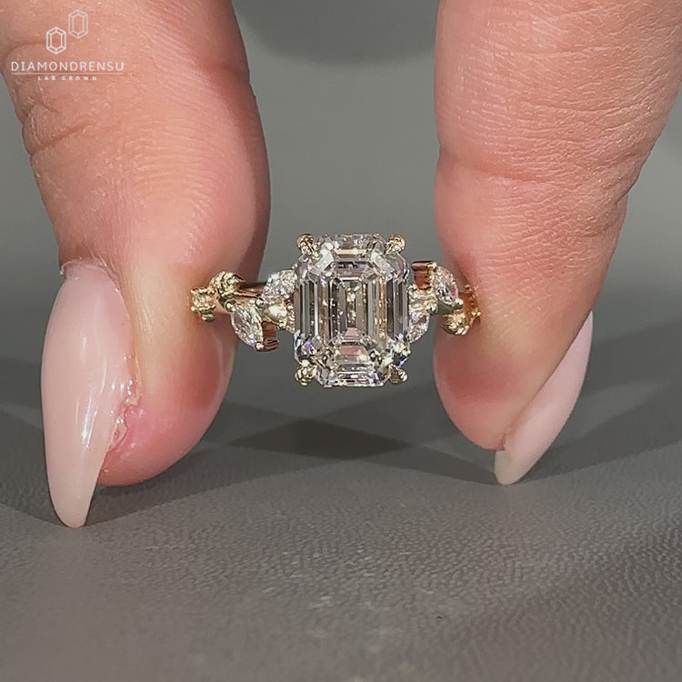 Emerald old european cut diamond ring with marquise and round side stones.
