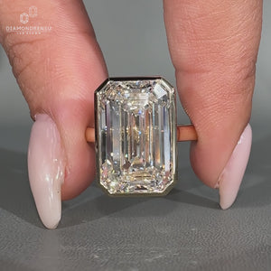 Emerald cut diamond ring in bezel setting.
