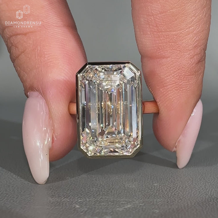 Emerald cut diamond ring in bezel setting.
