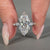 Marquise diamond ring with round side stones.
