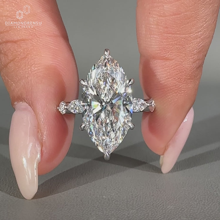 Marquise diamond ring with round side stones.
