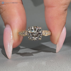 Round cut diamond ring with tapered shank and milgrain.