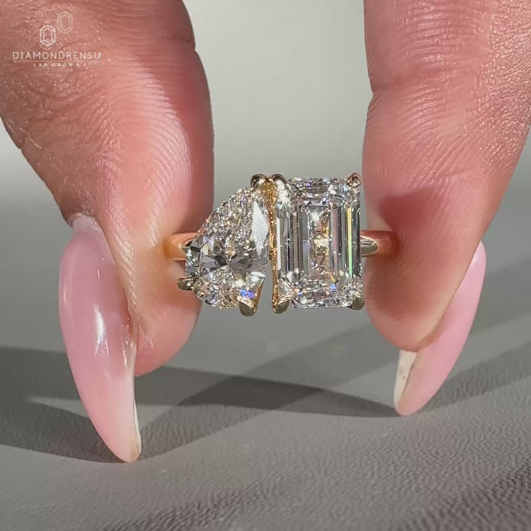 Pear and emerald cut ring set in yellow gold.
