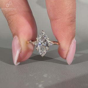 Marquise center diamond ring with pear side accents.