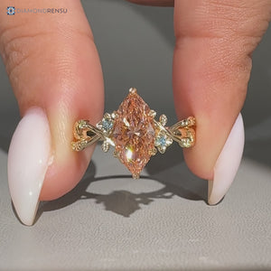 Marquise diamond ring with pink center stone and round sides.
