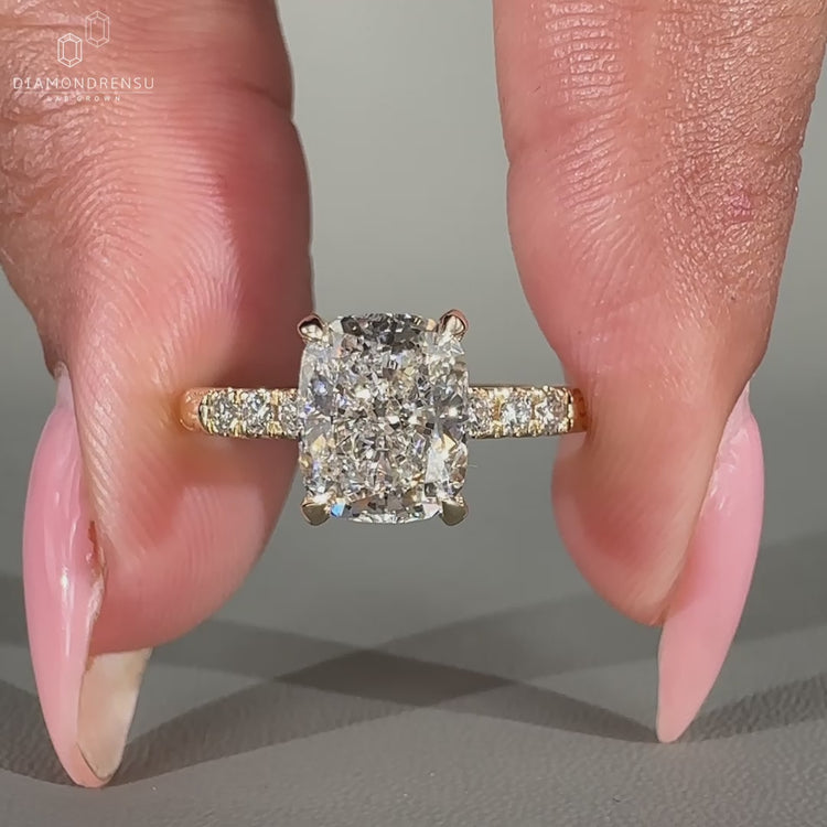 Pave round cut diamond band adds detail to this cushion hidden halo ring.
