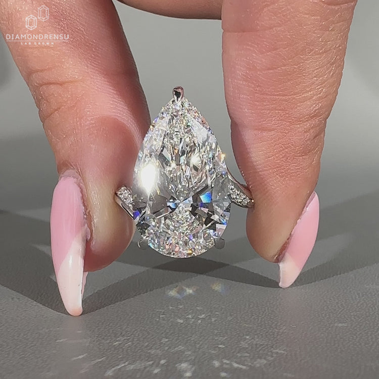 Pave round diamond ring with pear center.
