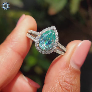 Cyan blue moissanite ring set in a bold and vibrant pear shape.
