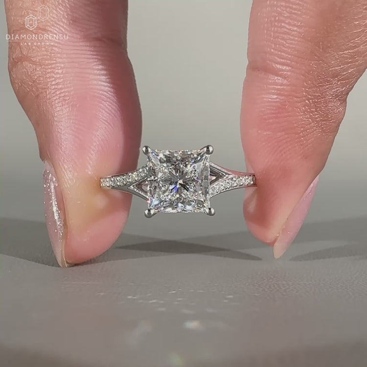 Round cut engagement ring with pave setting and split shank.
