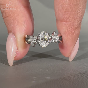 Twisted shank ring featuring marquise and round side stones in white gold.
