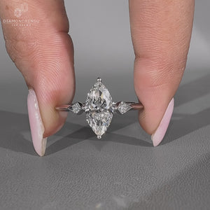 Three stone engagement ring with marquise and round side stones.
