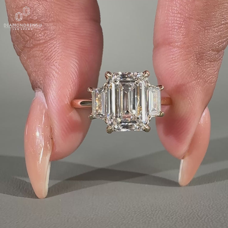 Three stone anniversary ring featuring a beautiful emerald cut diamond center.
