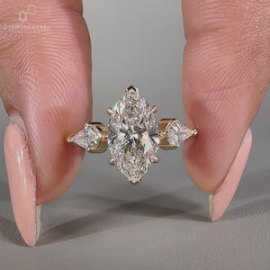 Marquise diamond ring in yellow gold with tapered shank design.
