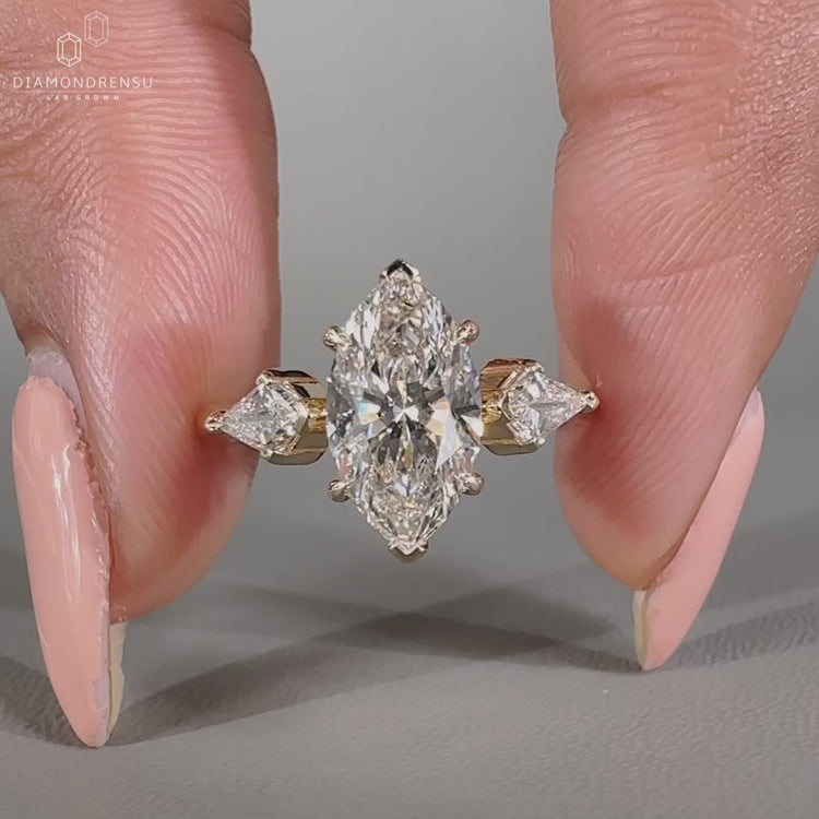 Marquise diamond ring in yellow gold with tapered shank design.
