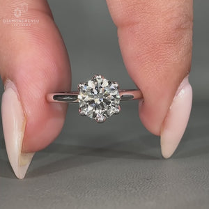 She wears a round diamond solitaire engagement ring.
