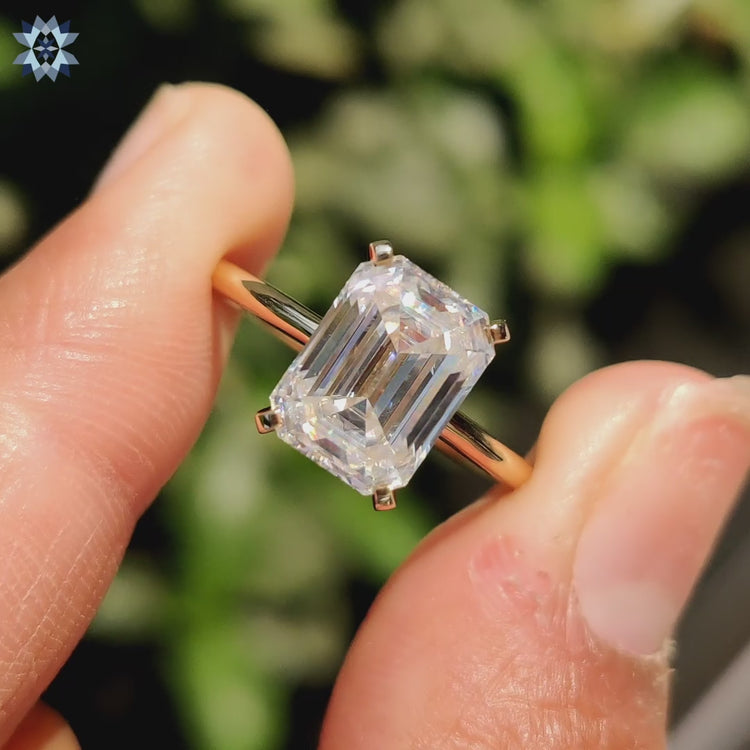 Emerald cut moissanite ring with a sleek band.
