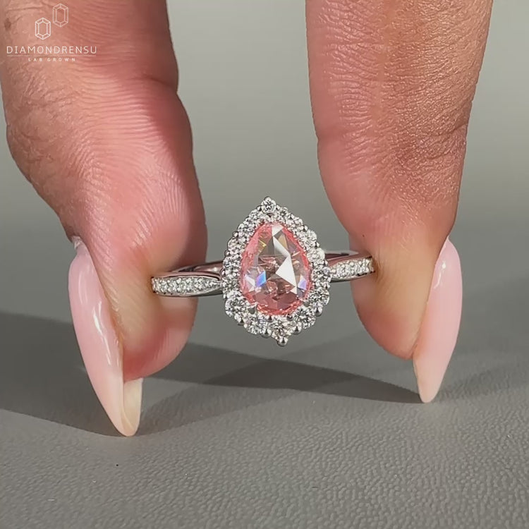 Pear halo ring with pave round cut diamond band.