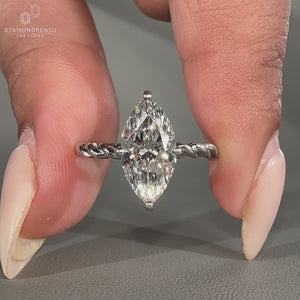 Compass prong setting engagement ring with a marquise diamond, designed for a modern look.
