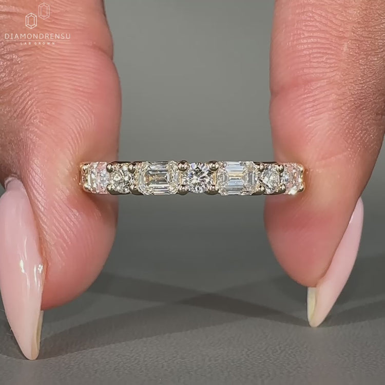 Emerald and round wedding band designed with alternating diamond shapes.
