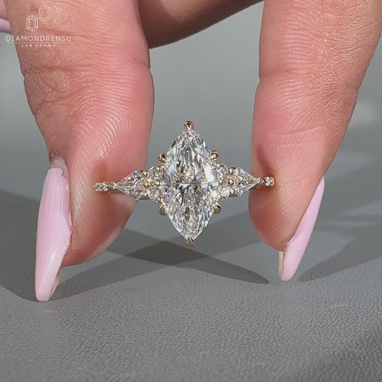 Muse setting ring featuring marquise diamond and round side stones.
