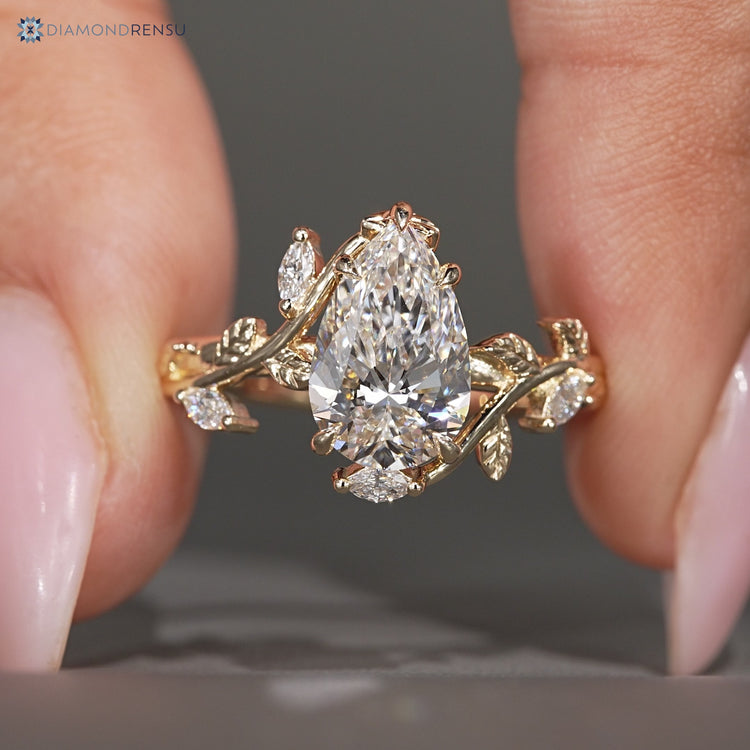 Pear cut lab grown diamond ring with marquise stones.