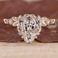 Nature inspired diamond ring with coffin center stone and round side stones.