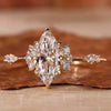 A beautiful vintage marquise engagement ring with round sidestones and knife edge band displayed in a jewelry box.