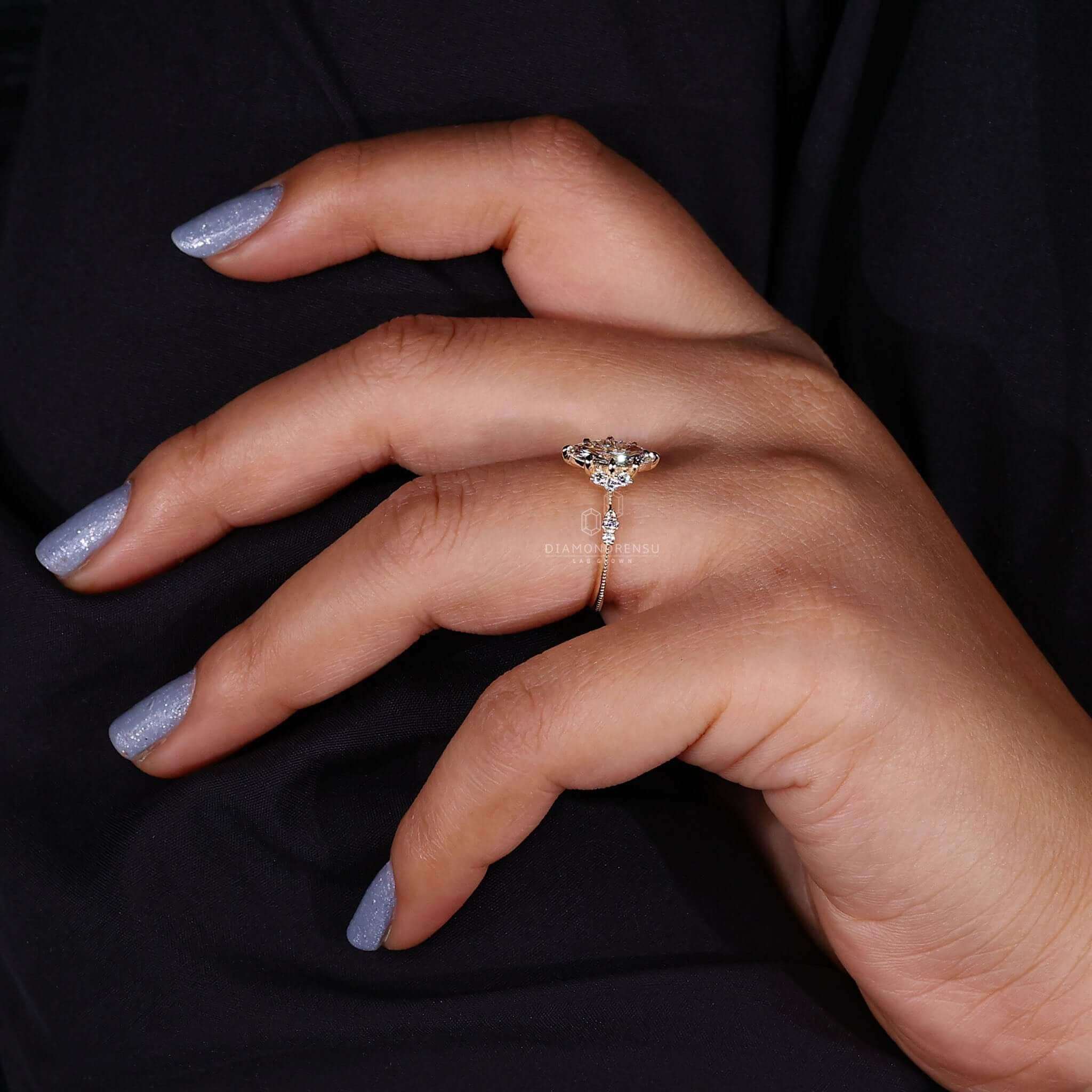 Close-up of a woman’s hand wearing a unique marquise cut ring, featuring a vintage engagement ring design with sidestones and claw prongs.