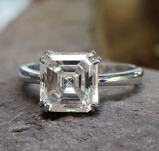Close-up of an Asscher engagement ring with intricate detailing.
