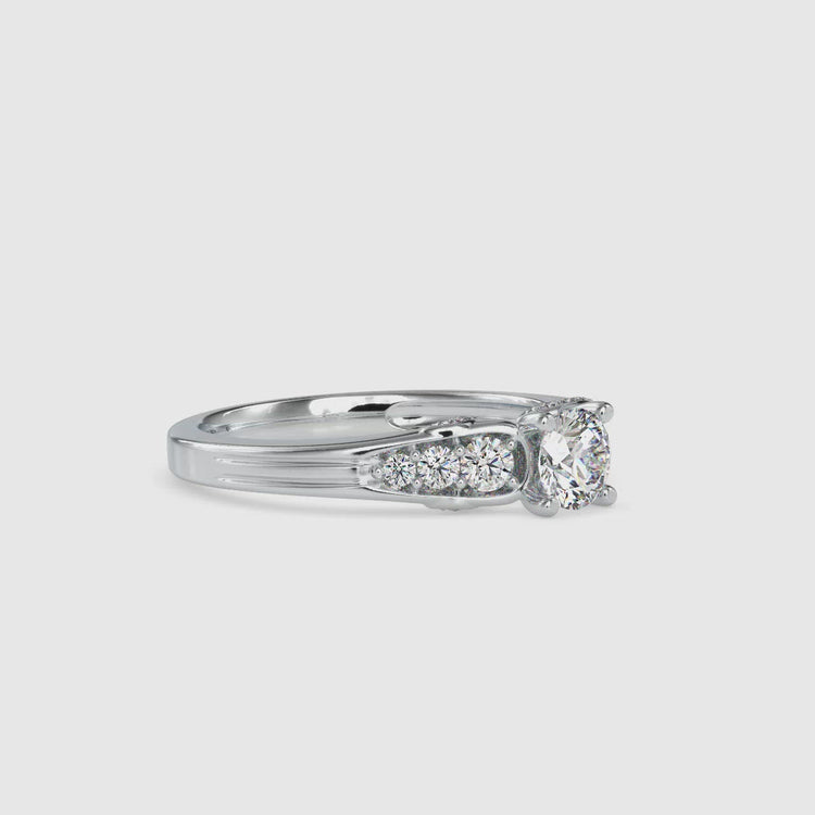 Round engagement ring with diamond accents and a tapered design.
