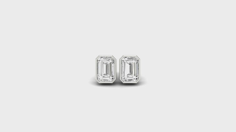 Classic bezel stud earrings featuring emerald cut diamonds, crafted with handmade jewelry.

