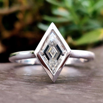 Close-up of a bezel engagement ring in elegant lighting.
