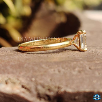 Emerald solitaire ring featuring a brilliant moissanite gem.
