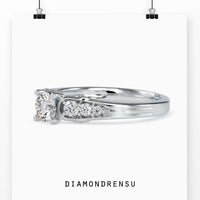 Tapered diamond engagement ring with brilliant cut center and side stones.
