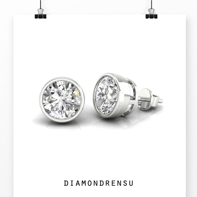 Gold round stud earrings with bezel set diamonds, ideal for an understated luxury look.
