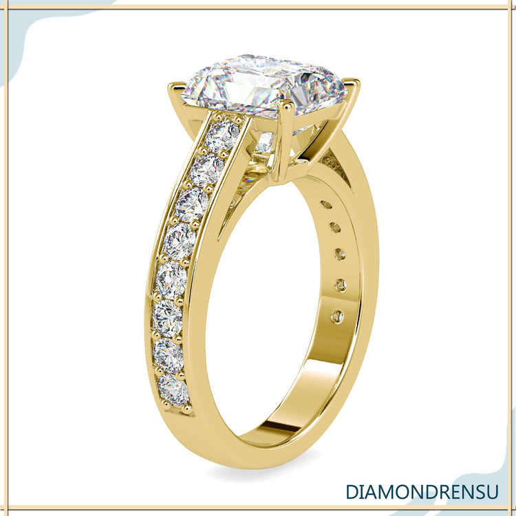 A handmade jewelry piece with a radiant cut moissanite and a 4-prong engagement ring setting.
